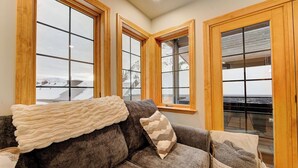 A cozy living room with a gray sofa, a white throw blanket, and a woven basket. - The Baldy Traverse Retreat ski-in/out to Snowbird complimentary shuttle to Alta (Snowbird)