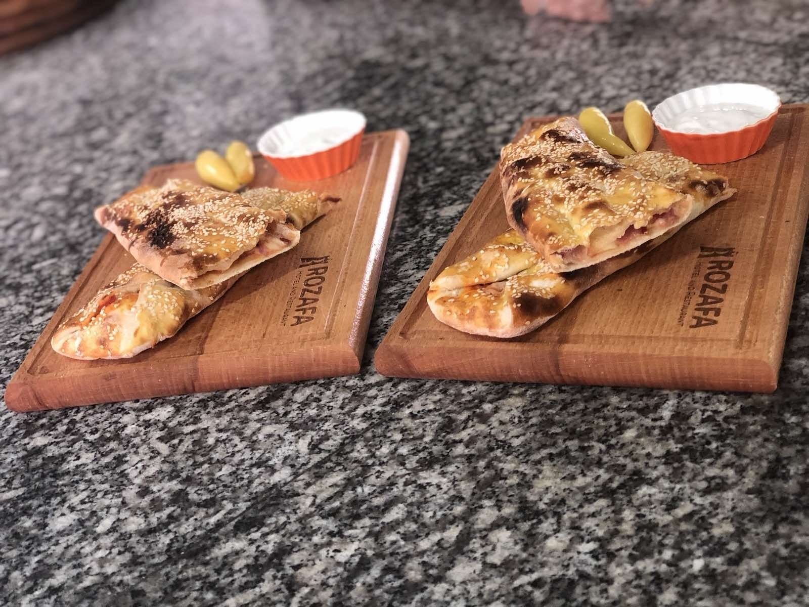 Two wooden serving boards with food items and condiments.