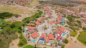 Luftaufnahme eines Küstenresorts mit mehreren Gebäuden, Straßen und einer zentralen Kreisverkehr.