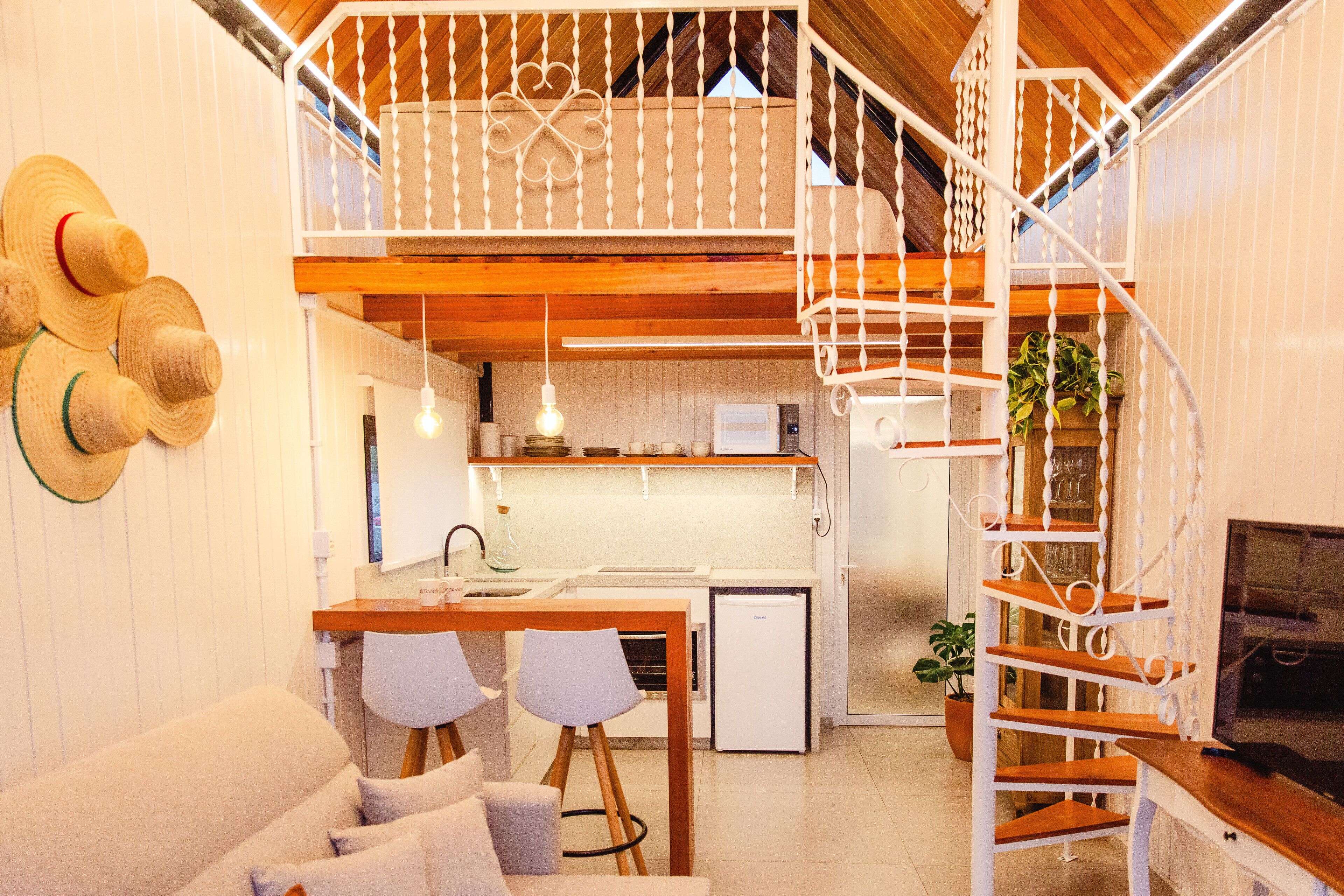 Une cuisine moderne avec un plafond en bois, des murs blancs et un escalier blanc.