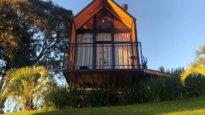 A two-story wooden house with a gabled roof, large windows, and a balcony. - Alta Vista Cabanas (Garibaldi)