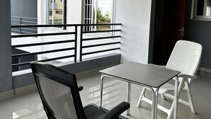 A modern room with a balcony, a table, and two chairs.