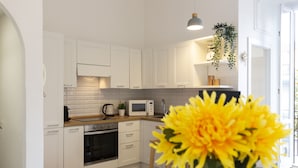 A modern kitchen with white cabinets, a microwave, and a coffee maker. - nota-Mi - Mezzofanti TRE PONTI (Milan)