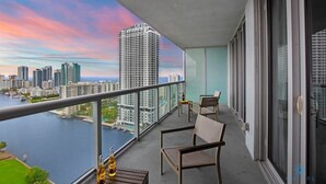 A balcony with a view of a city skyline and a body of water. - Infinite View w/ Balcony| Amazing Pool + Gym (Hallandale Beach)