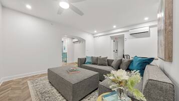 A modern living room with a sectional sofa, a coffee table, and a ceiling fan.