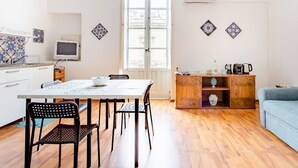 Une cuisine moderne avec une table à manger, des chaises et un buffet en bois agrémenté d’objets décoratifs.