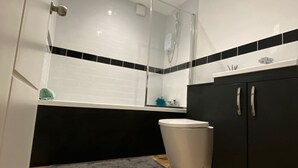 Moderni kylpyhuone, jossa on suihku, wc ja pesuallas.