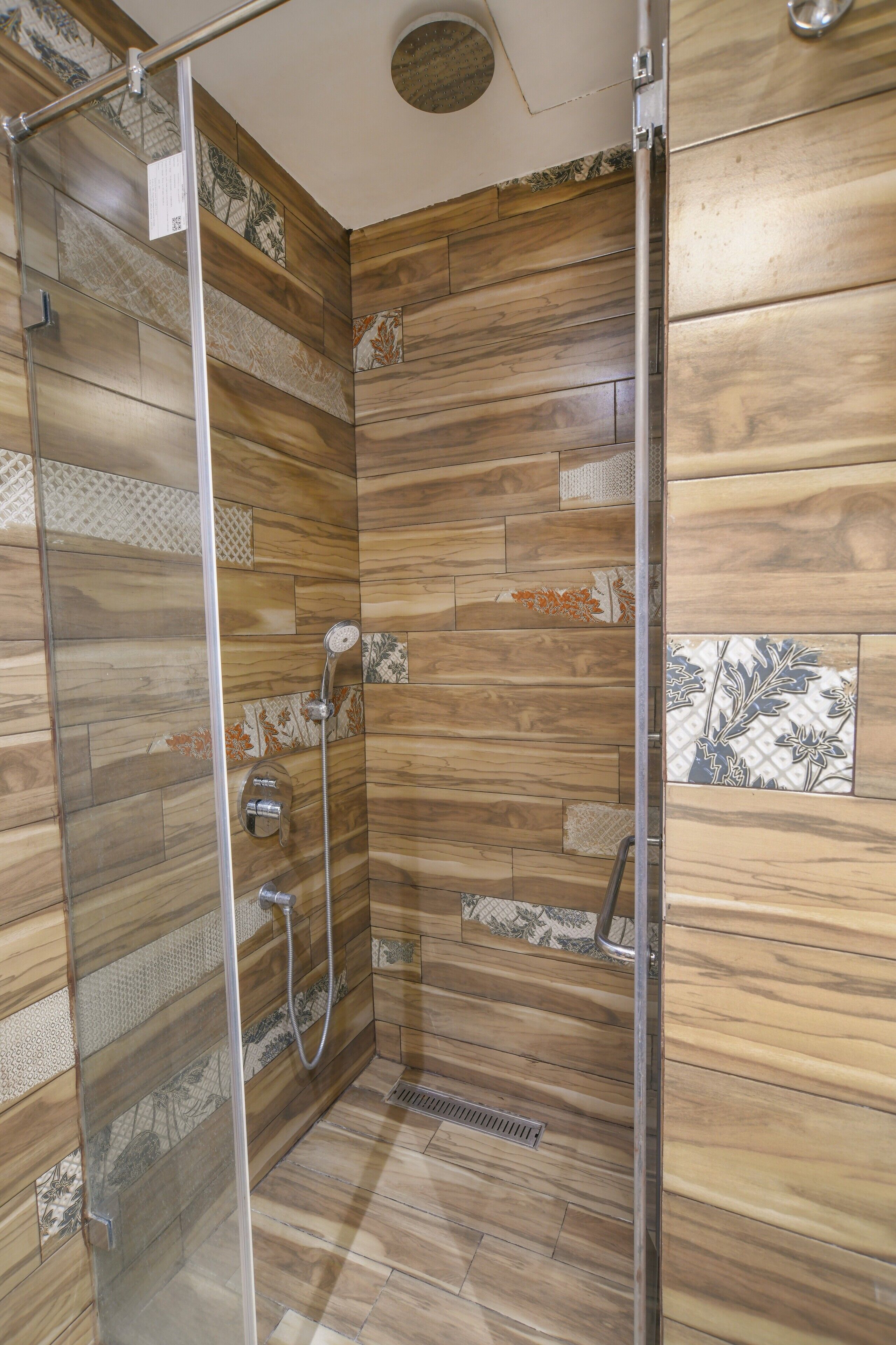 Ducha con paneles de madera y puerta de cristal.