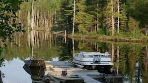 A dock with boats and a motorboat. - Jim's Cottage (Egan-Sud)