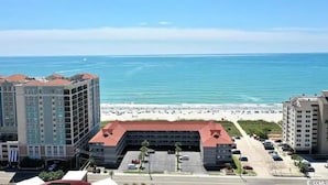 A coastal hotel with multiple floors, a parking lot, and a beach view. - Tequila Sunrise - 2BR Oceanfront (North Myrtle Beach)