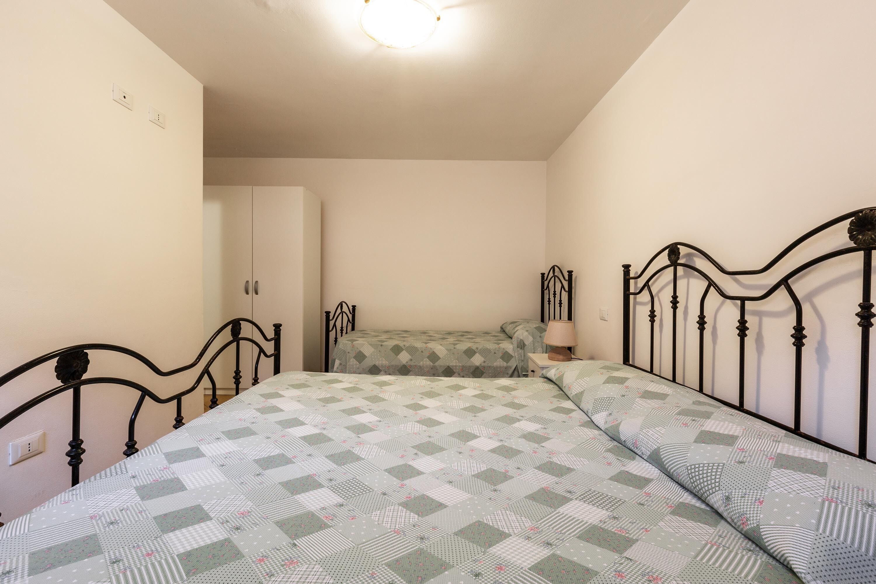 A bedroom with a bed, a nightstand, and a wardrobe.