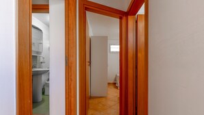 Un pasillo con puertas de madera que dan a un baño y un dormitorio.