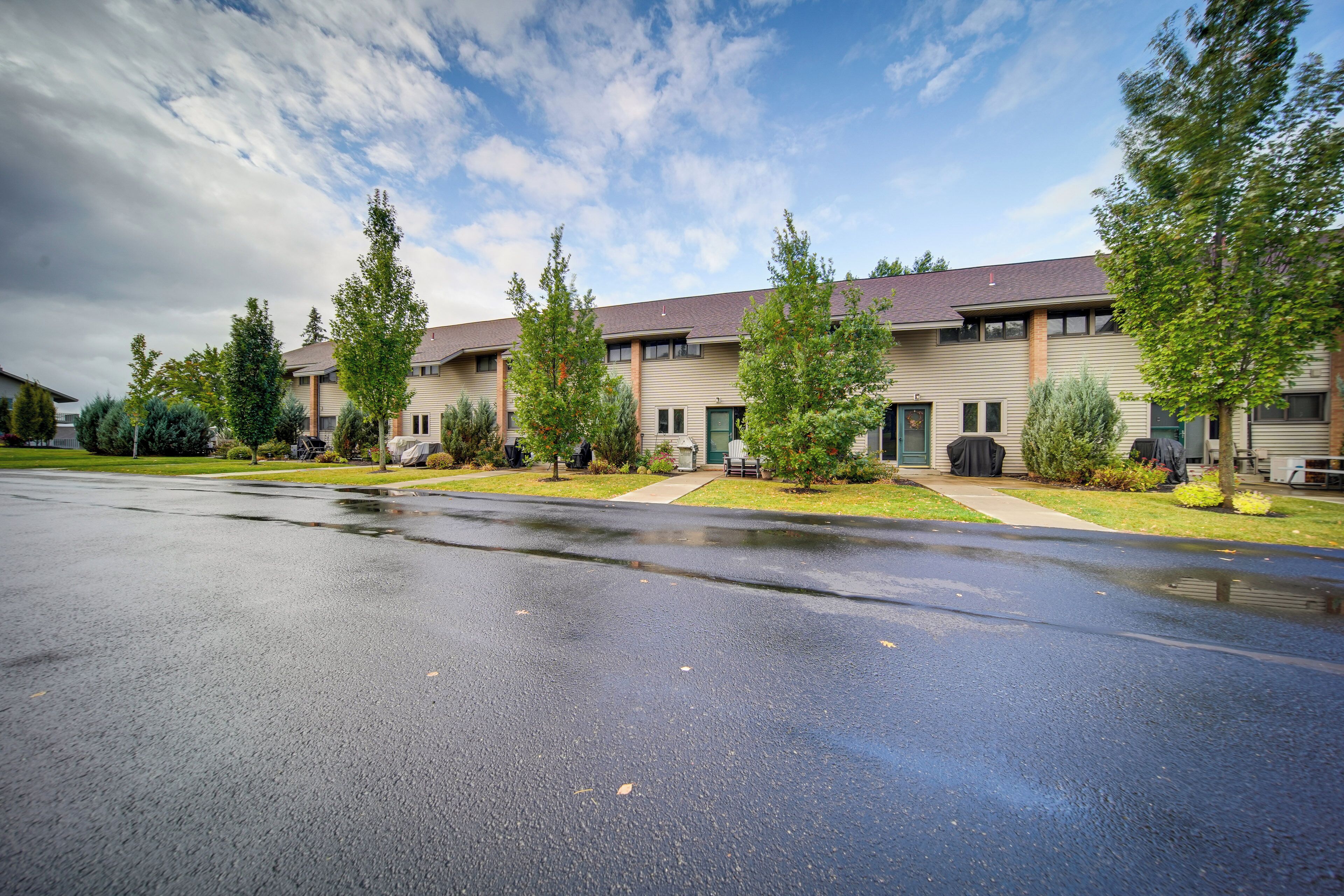 A multi-story building with a flat roof and a parking lot in front.