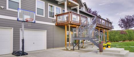 A two-story house with a basketball hoop, a covered porch, and a staircase leading to the upper level.