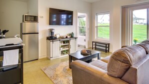 A modern kitchen with a built-in microwave, refrigerator, and a flat-screen TV above the cabinets. - Chic & Modern Snohomish Hideaway on a Working Farm (Snohomish)