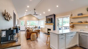 A spacious kitchen with a central island, a dining area with a sofa, and a fireplace. - Lakefront Home w/ Private Dock in Sunrise Beach! (Sunrise Beach)