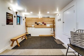 Habitació amb un llit superposat, una banca, un escriptori i una porta.