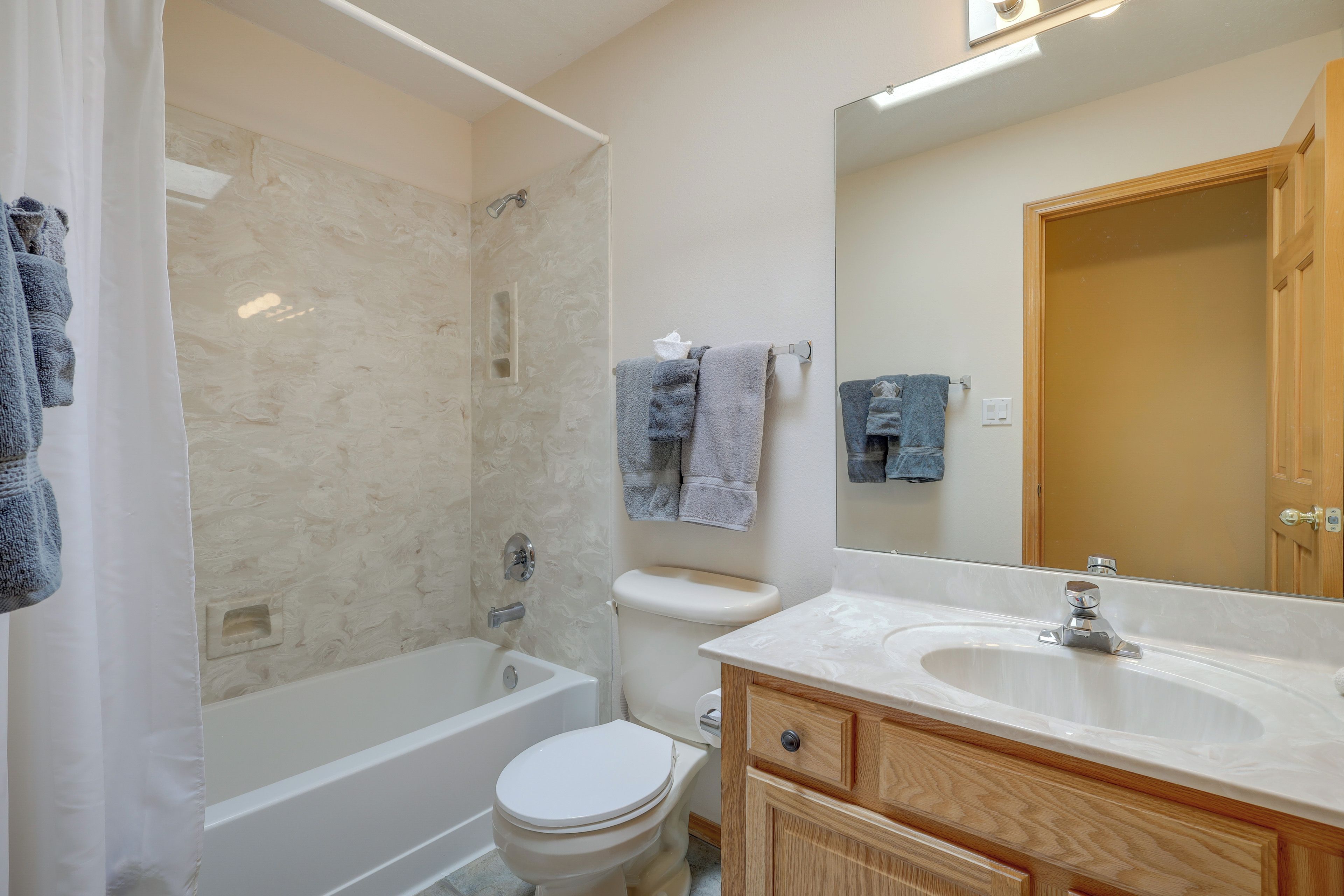A bathroom with a bathtub, toilet, and sink.