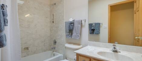 A bathroom with a bathtub, toilet, and sink.