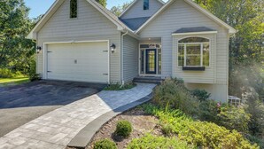 A two-story house with a garage, a front porch, and a landscaped yard. - Waterfront Lusby Escape w/ Fire Pit & Kayaks! (Lusby)