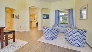 Ein Wohnzimmer mit einer Couch, zwei Hocker, einem Holztisch und einem Teppich.