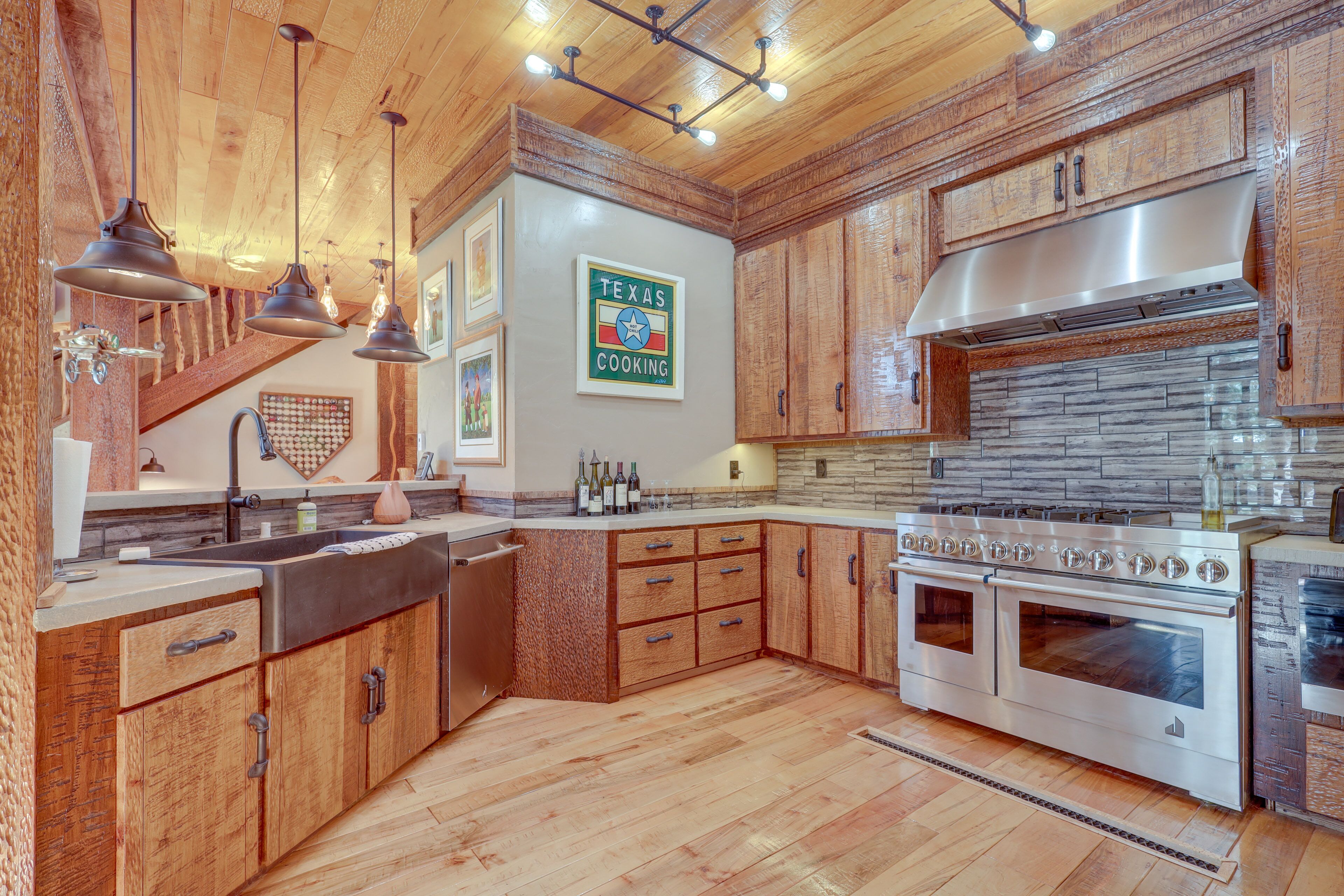 Una cocina con armarios de madera, una estufa de acero inoxidable y un letrero de Texas Cooking.