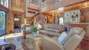 A spacious lobby with leather sofas, a wooden coffee table, and a large window. A sign for the Arrow Motel is visible on the wall.