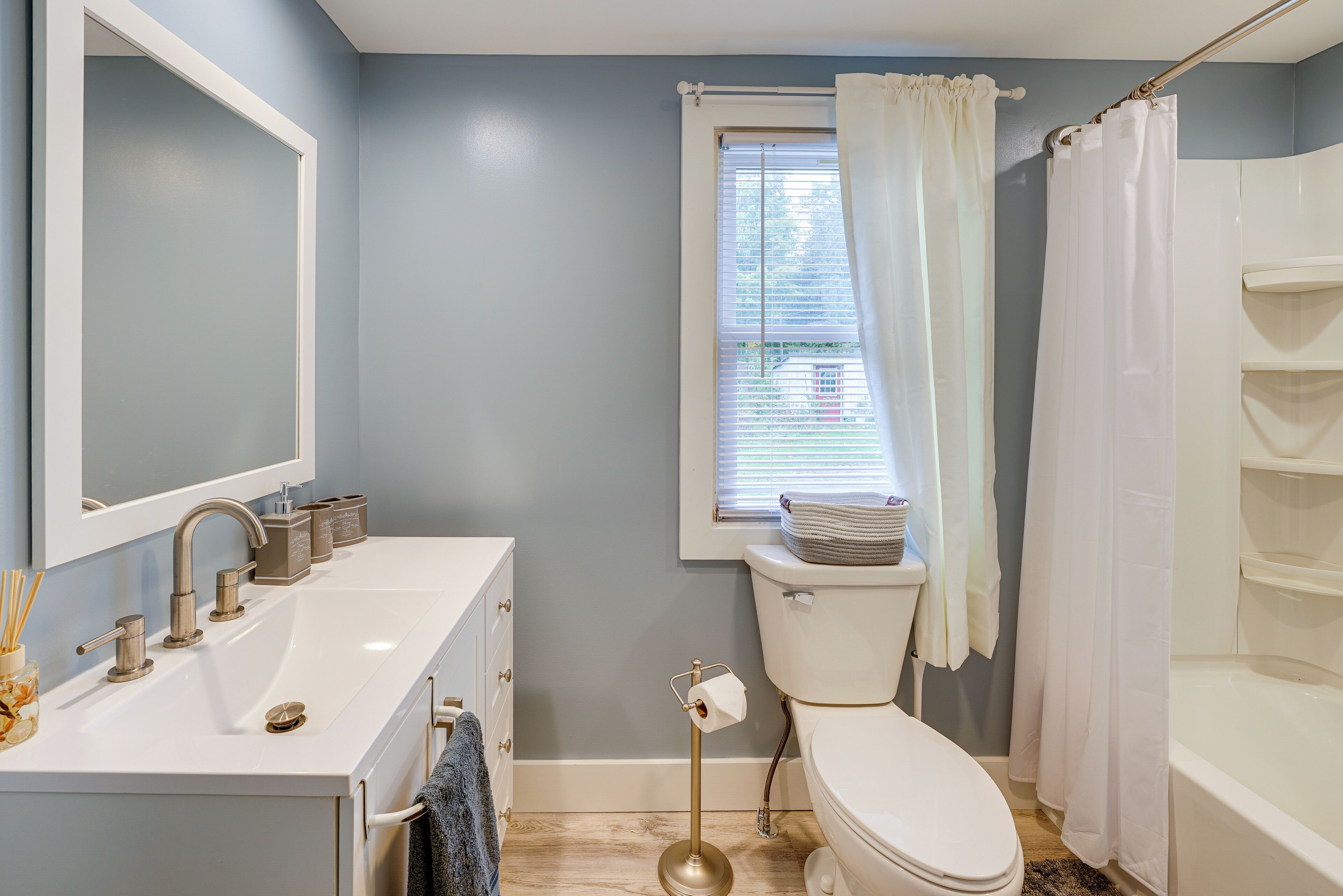 Une salle de bain équipée d’un lavabo, d’un miroir, de toilettes et d’une baignoire.