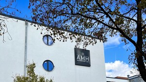 A modern building with a sign reading "AMH WOHEN AUF ZEIT". - AMH - Wohnen auf Zeit (Munich)