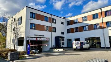 Ein modernes Gebäude mit einem Schild für 'Tiefgarage' und einem Parkschild, das eine maximale Parkdauer von 10 Minuten anzeigt.