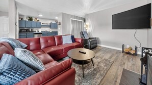A modern living room with a sectional sofa, a coffee table, and a TV. - Snowy Peaks Haven | Walk to Slopes & Park (Brian Head)