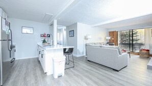 Un espacio de estar moderno con cocina, comedor y zona de estar con vistas al exterior.