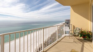 Ein Balkon mit Blick auf das Meer, ein Stuhl und ein Blumentopf.