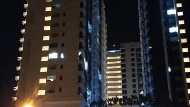 Un edificio de gran altura con letreros iluminados que dicen 'The Loft Residences'.