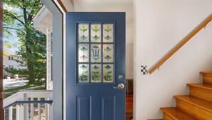 A blue door with stained glass panels, a wooden staircase, and a white wall. - Shuffleboard - Gym - BBQ (Minneapolis)
