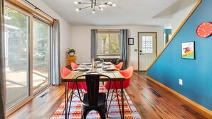 A dining area with a wooden table, orange chairs, and a patterned rug. - Shuffleboard - Gym - BBQ (Minneapolis)
