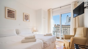A hotel room with a bed, two framed pictures, a TV, a chair, and a balcony with a railing. - Apartamentos Capricho del Mar (Torremolinos)