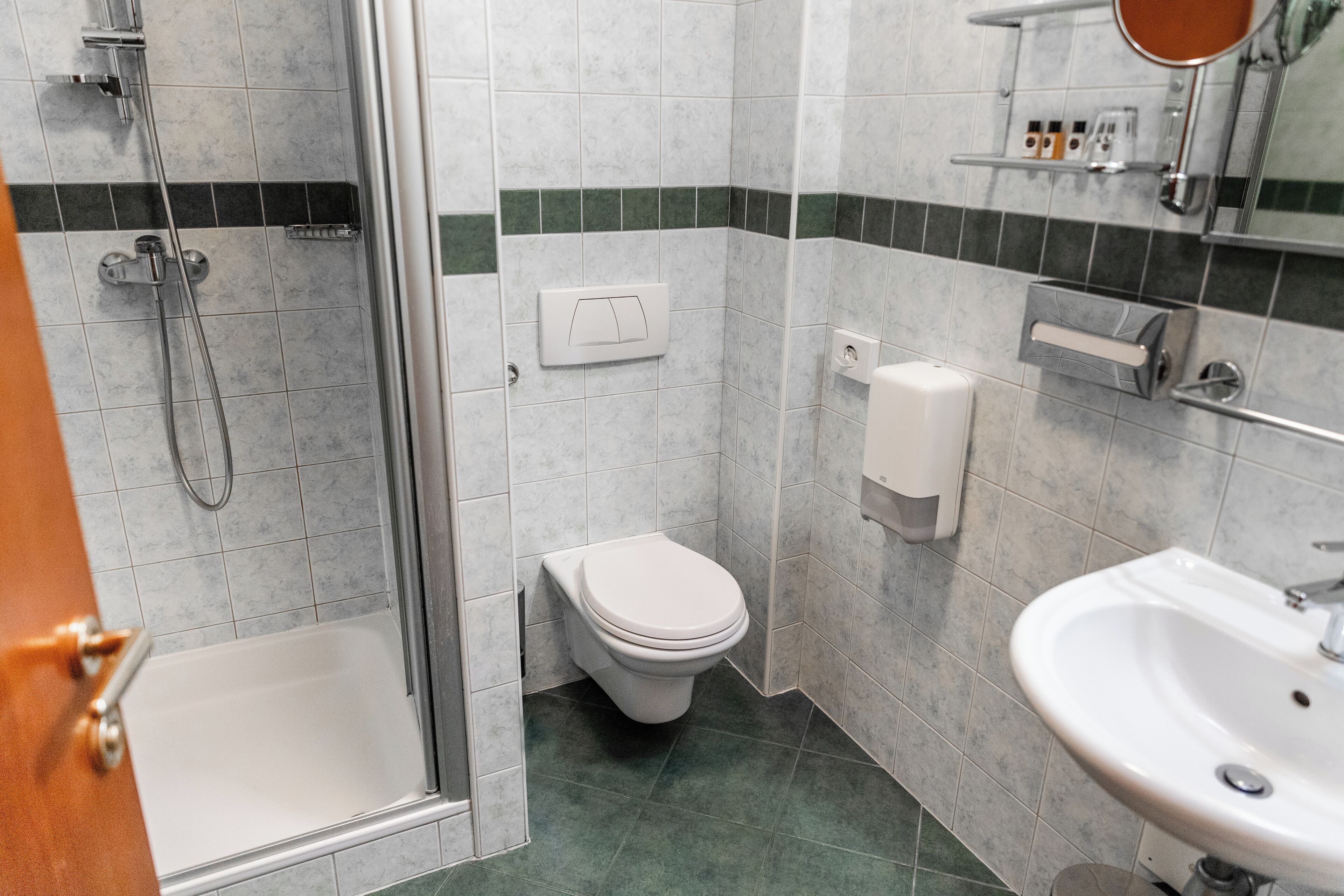 A bathroom with a shower, toilet, and sink.