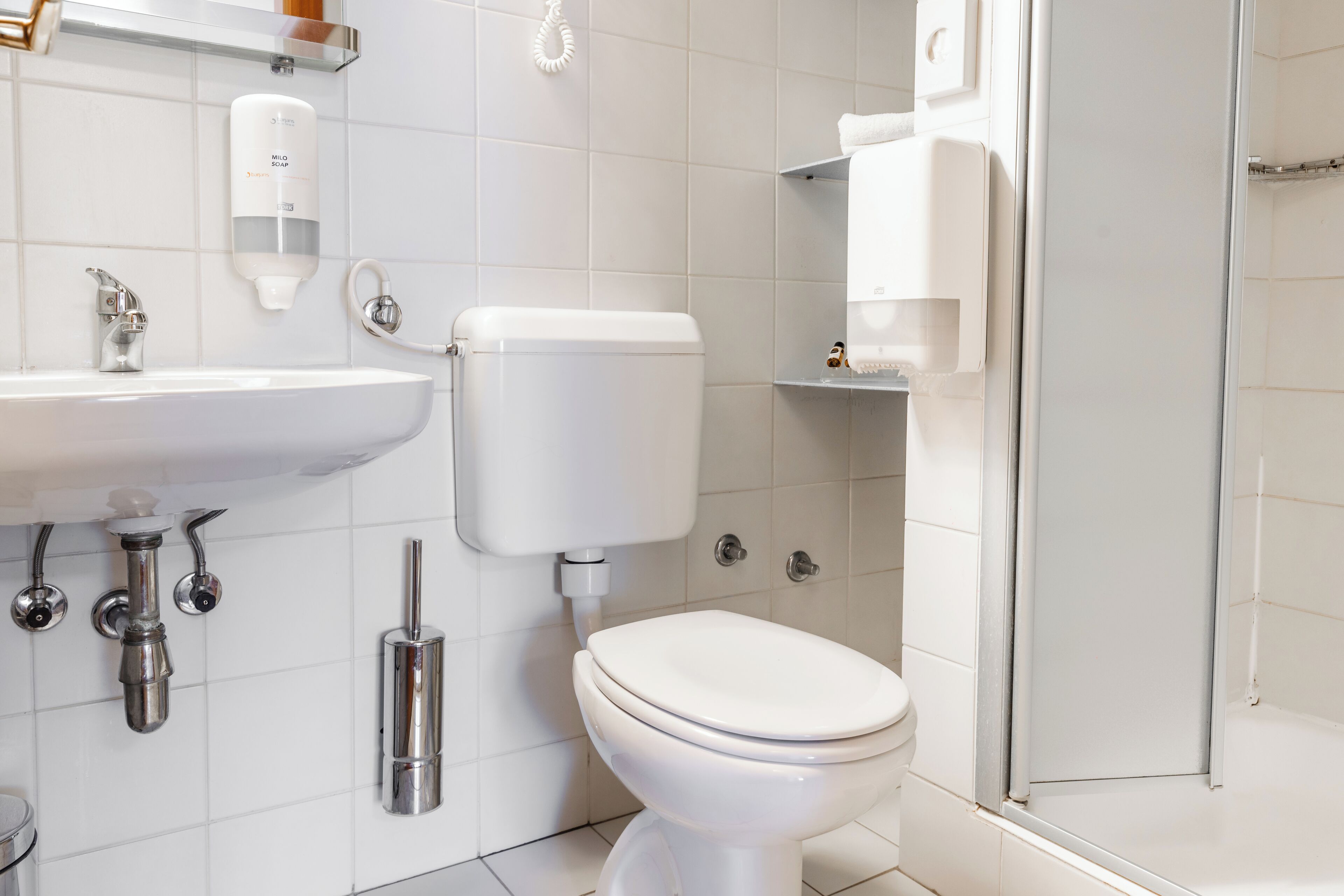 A modern bathroom with a white sink, toilet, and shower.