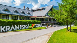 A building with a modern architectural design, featuring a prominent sign with the name 'Kranjska Gora'.