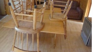 Ein Holzinterieur mit einem runden Tisch und vier Stühlen.