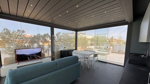 Un espacio habitable moderno con sofá, comedor y cocina.