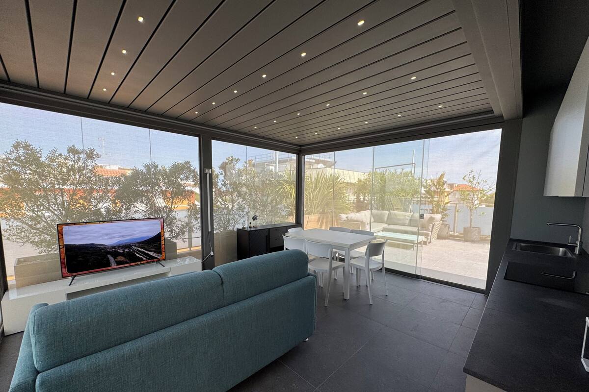 A modern living space with a sofa, dining area, and kitchen.