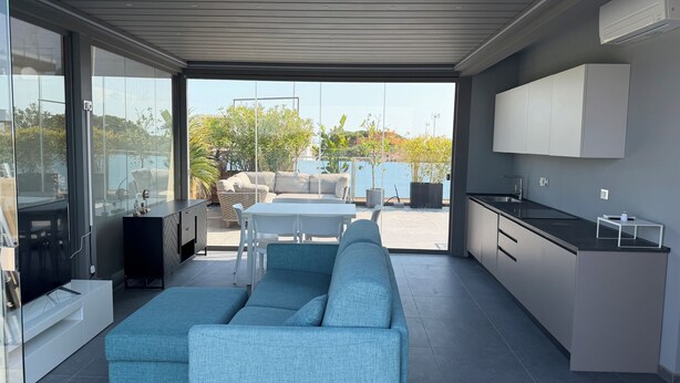 Una cocina moderna con comedor, sofá y vistas al exterior.