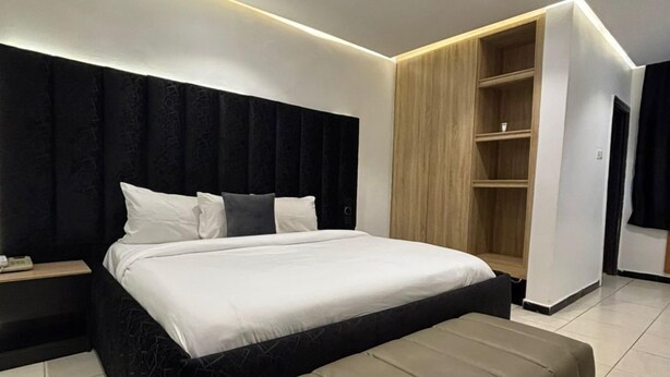 Ein modernes Schlafzimmer mit einem großen Bett, einem Holzschrank und einer Bank.