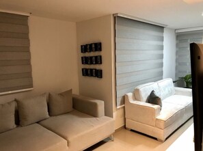 Relax in this stylish living room with two sofas, framed artwork, and a large window.
