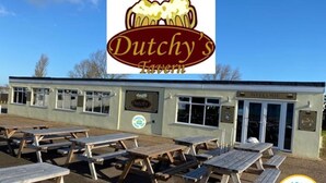 Le bar Dutchy's, avec ses tables de pique-nique en plein air et un ciel d'un bleu éclatant.