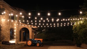 Un edificio rústico de piedra con un tractor estacionado al frente.