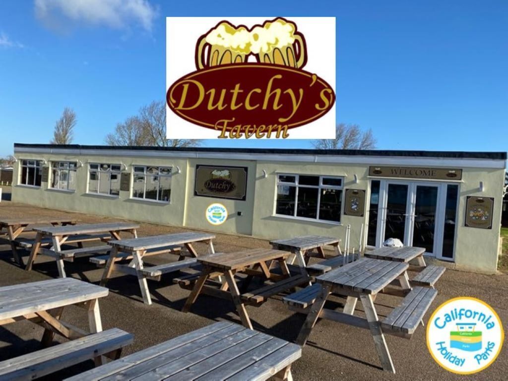 El Tavern Dutchy con mesas de picnic al aire libre y un cielo azul despejado.