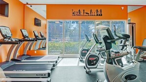 Un gimnasio con cintas de correr, elípticas y bicicletas estáticas.